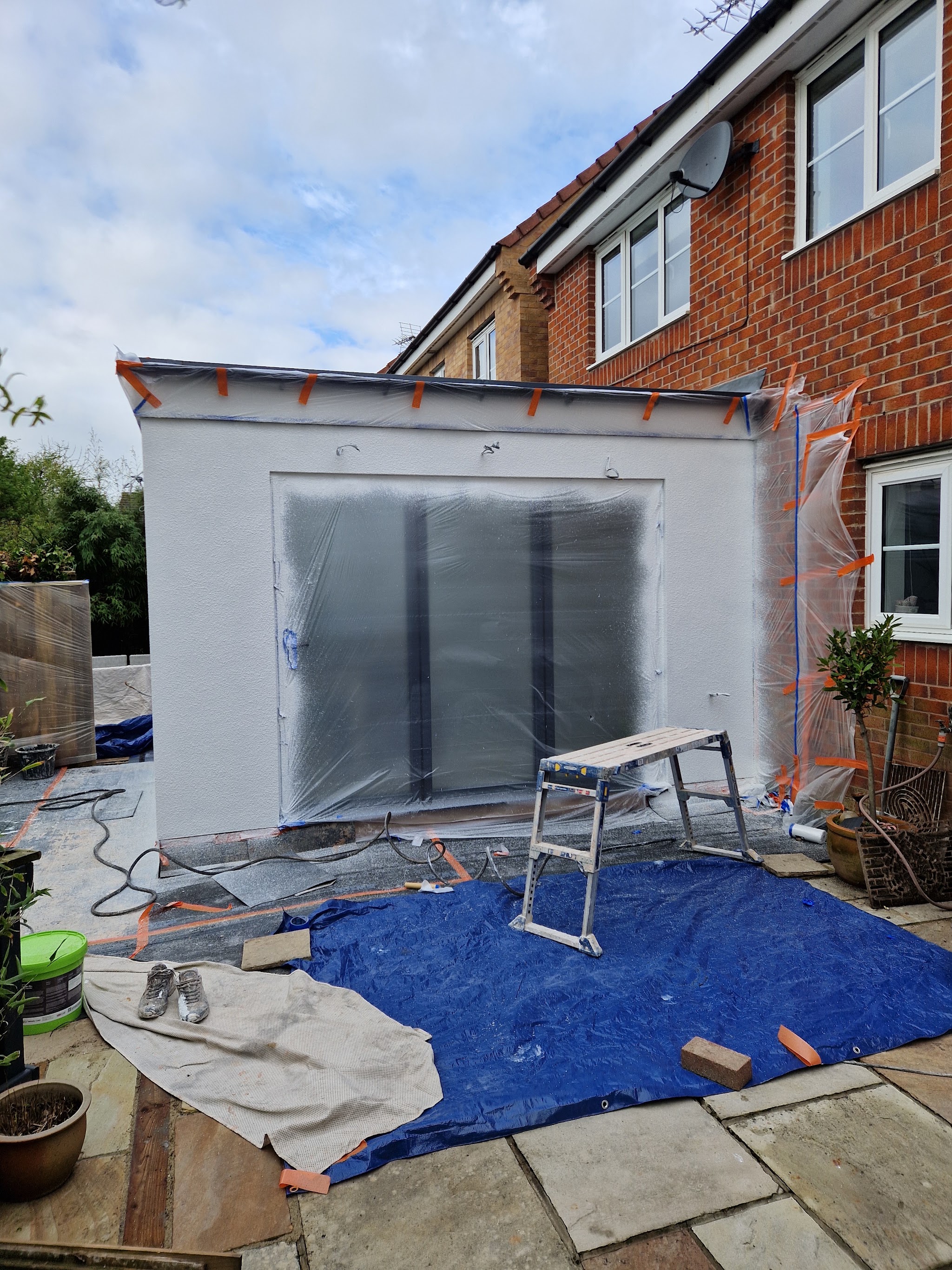 Rear extension being rendered, windows masked and the patio sheeted