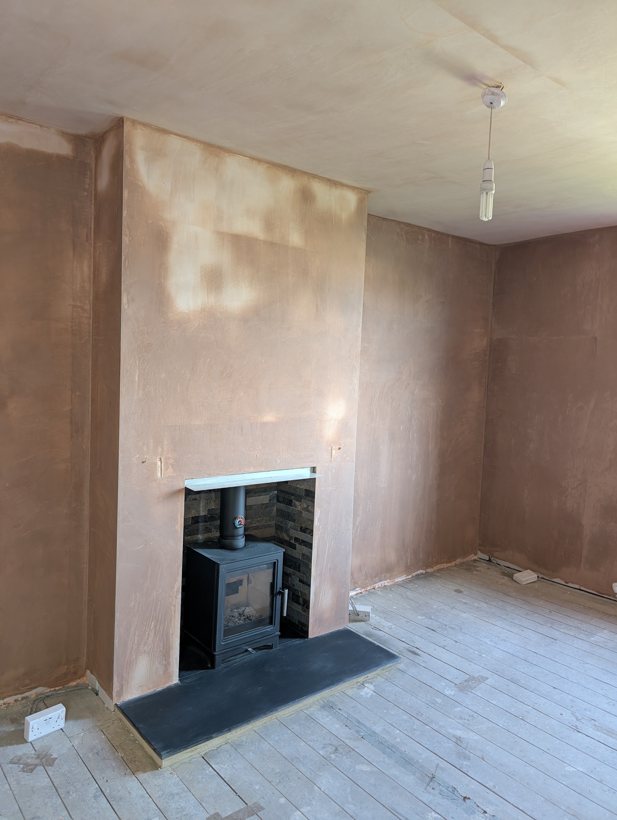 Living room freshly skimmed around the chimney breast, plaster still drying