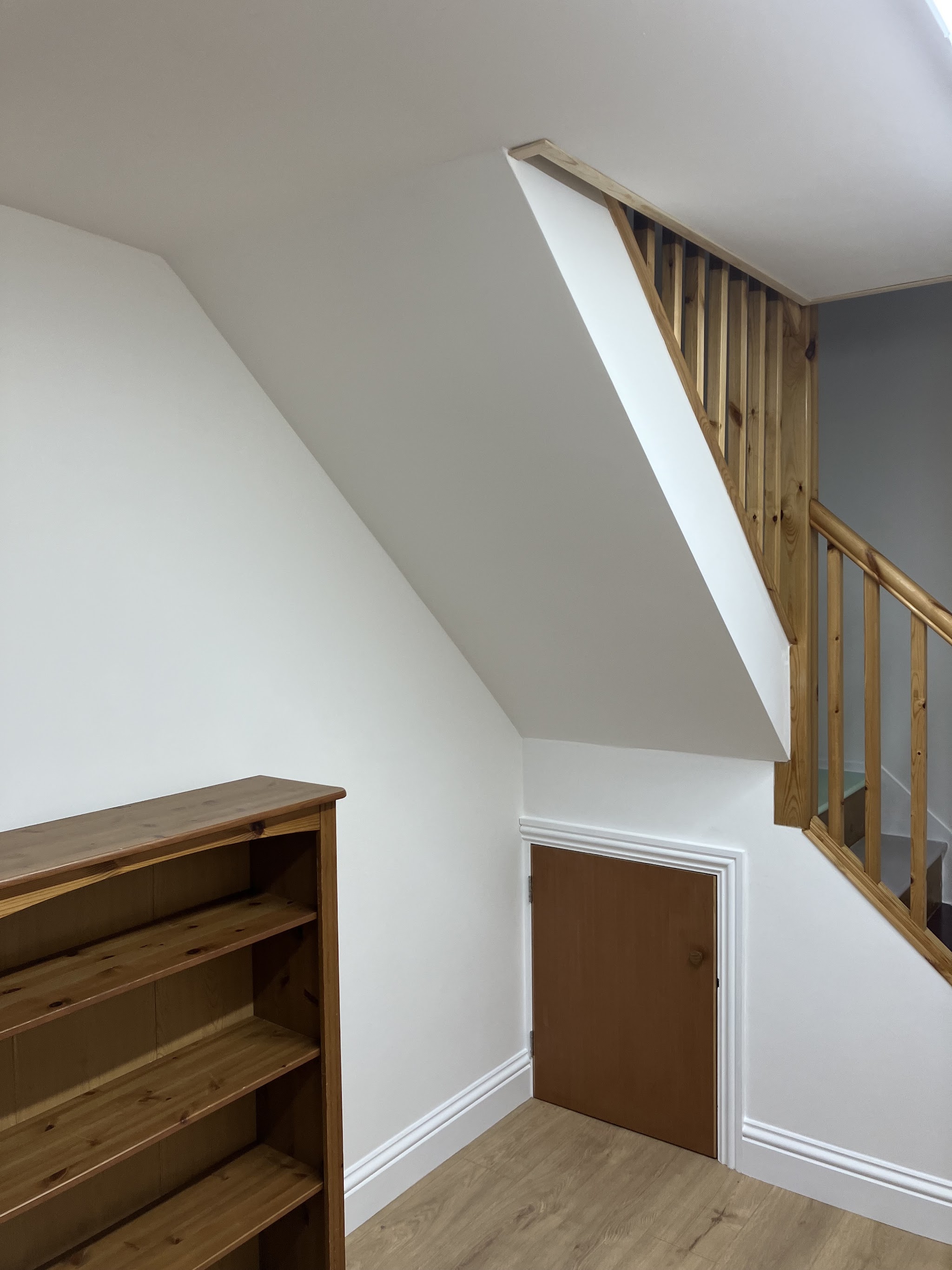 Finished white hallway and under-stairs wall with timber spindles